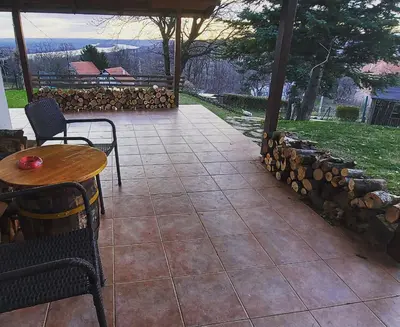 a patio with a table and chairs and a stone wall at Hacienda Guster in Ritopek