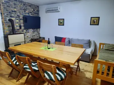 a wooden table and chairs in a living room with a couch at Vila Sava in Jarak