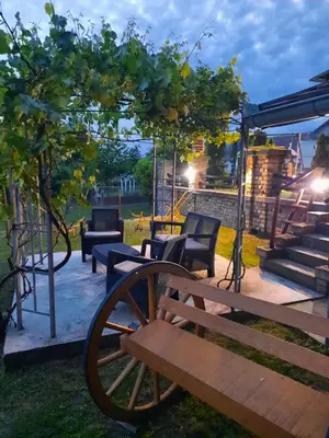 a patio with a bench and chairs under a tree at Vila Sava in Jarak