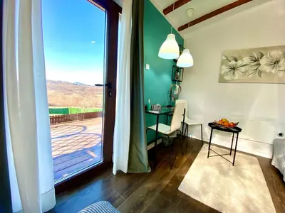 a living room with a sliding glass door and a table at Avala Sunset Apartments in Belgrade