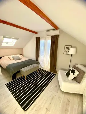 a attic bedroom with a bed and a couch at Avala Sunset Apartments in Belgrade