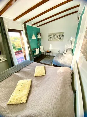a bedroom with a bed with two yellow pillows on it at Avala Sunset Apartments in Belgrade