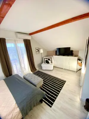 a bedroom with a bed and a large window at Avala Sunset Apartments in Belgrade