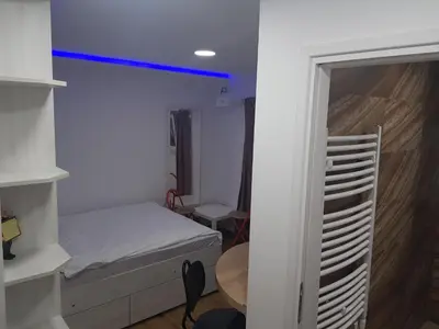 a small room with a bed and a blue light at studio skadarlija in Belgrade