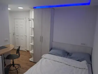 a bedroom with a bed with a blue light above it at studio skadarlija in Belgrade