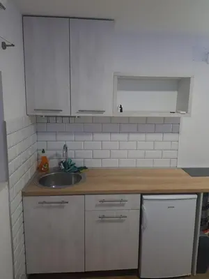 a kitchen with white cabinets and a sink at studio skadarlija in Belgrade