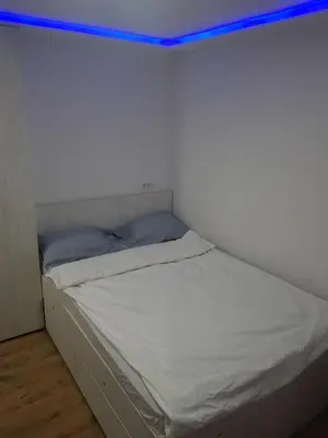 a bed in a room with a white wall at studio skadarlija in Belgrade