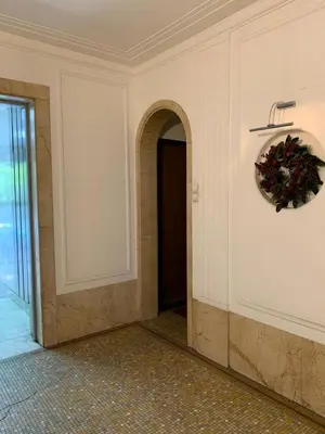 a hallway with a wreath on the wall and a door at City centre apartment in Belgrade