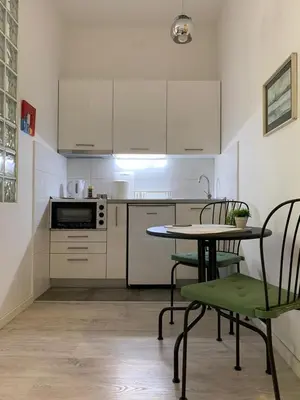 a kitchen with a table and chairs and a microwave at City centre apartment in Belgrade