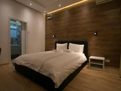 a bedroom with a large bed with a wooden wall at Studio 138 in Belgrade