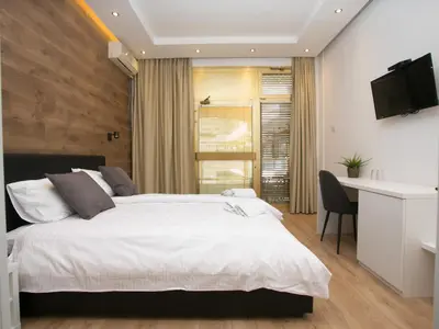 a bedroom with a large white bed and a desk at Studio 138 in Belgrade