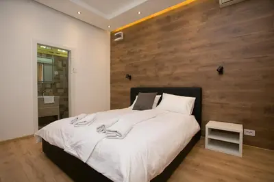 a bedroom with a large bed with a wooden wall at Studio 138 in Belgrade