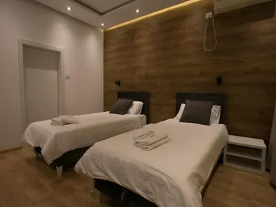 two beds in a room with wooden walls at Studio 138 in Belgrade