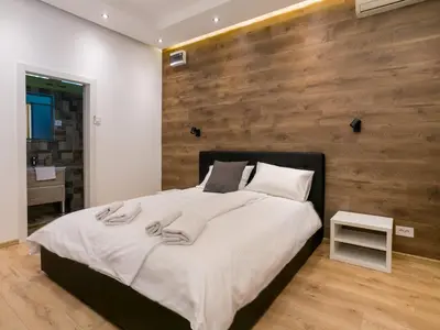 a bedroom with a large bed with a wooden wall at Studio 138 in Belgrade