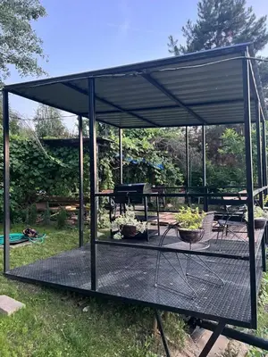 a metal pavilion with a picnic table and a grill at Beach House Belgrade in Belgrade