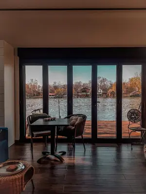 a dining room with a table and a view of the water at Beach House Belgrade in Belgrade