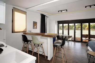 a kitchen and living room with a counter and chairs at Beach House Belgrade in Belgrade