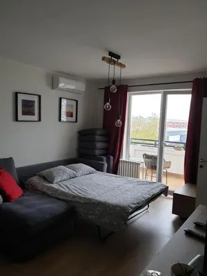 a bedroom with a bed and a couch and a window at TiTo LuX in Belgrade
