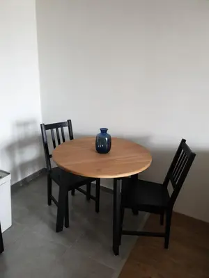 a wooden table with two chairs and a vase on it at TiTo LuX in Belgrade