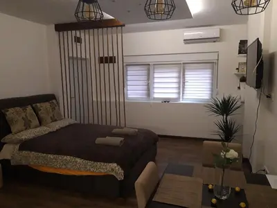 a bedroom with a bed and a couch and a window at Vilovski in Vračar (historical)