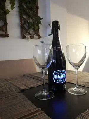 a bottle of beer and two wine glasses on a table at Vilovski in Vračar (historical)