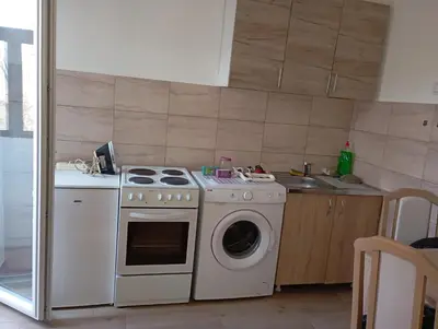 a kitchen with a stove and a washing machine at Nataly Apartment in Belgrade
