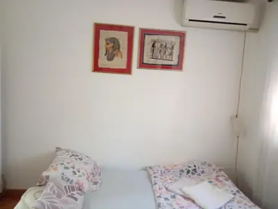 a bedroom with two pictures on the wall and a bed at Nataly Apartment in Belgrade