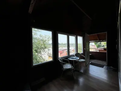 a room with windows and a table and chairs at Kuca i splav na reci Savi in Belgrade