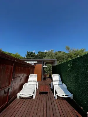 two white chairs sitting on a wooden deck at Kuca i splav na reci Savi in Belgrade