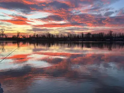 a sunset over a body of water with a cloudy sky at Kuca i splav na reci Savi in Belgrade