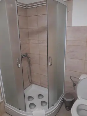 a shower with a glass door in a bathroom at Rita Apartman & Studio in Zrenjanin