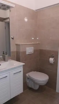 a bathroom with a toilet and a sink at Rita Apartman & Studio in Zrenjanin