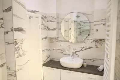 a white bathroom with a sink and a mirror at Natalie's Royal M in Belgrade