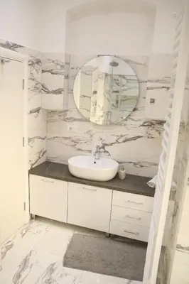 a white bathroom with a sink and a mirror at Natalie's Royal M in Belgrade