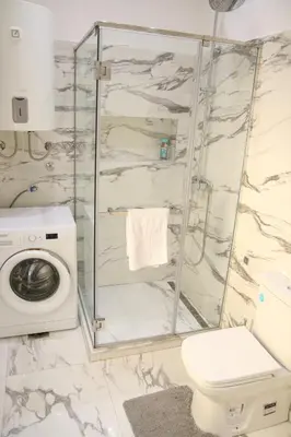 a bathroom with a toilet and a washing machine at Natalie's Royal M in Belgrade
