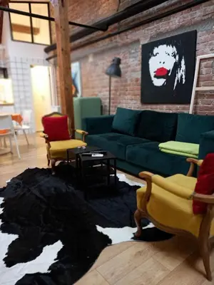 a living room with a green couch and a brick wall at Brickloft in the heart of Belgrade in Belgrade