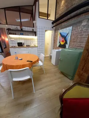 a dining room with a wooden table and white chairs at Brickloft in the heart of Belgrade in Belgrade