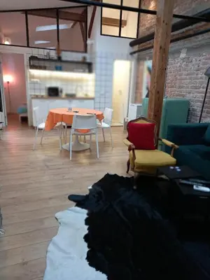 a living room with a table and chairs at Brickloft in the heart of Belgrade in Belgrade