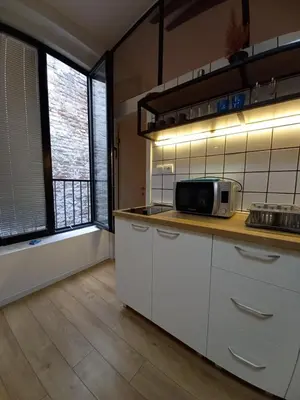 a kitchen with white cabinets and a microwave on a counter at Brickloft in the heart of Belgrade in Belgrade