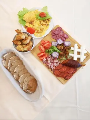 a table with three plates of food and bread at Garni hotel FILIA in Nova Pazova