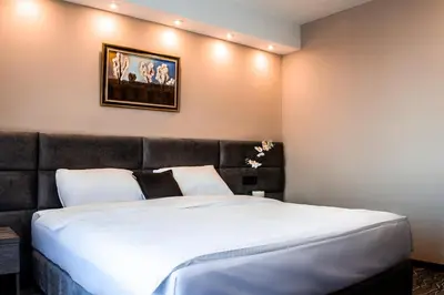 a bedroom with a large bed with a picture on the wall at Garni hotel FILIA in Nova Pazova