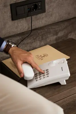 a hand is using a phone next to a box at Garni hotel FILIA in Nova Pazova