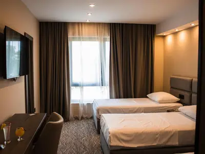 a hotel room with two beds and a window at Garni hotel FILIA in Nova Pazova