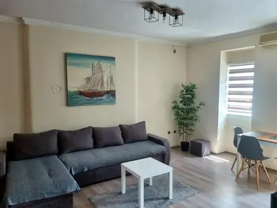 a living room with a couch and a sailboat painting at Dixy apartman in Belgrade
