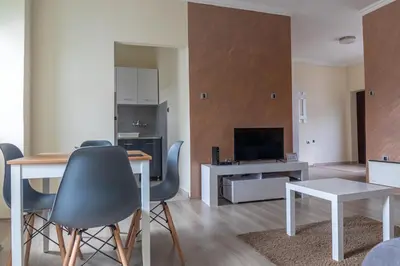a living room with a table and chairs and a television at Dixy apartman in Belgrade