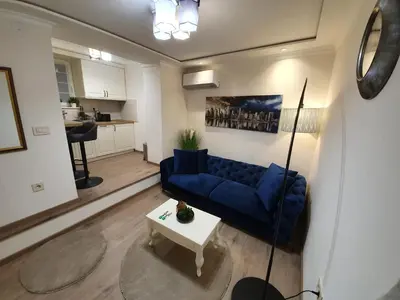 a living room with a blue couch and a table at Apartment My Home in Belgrade