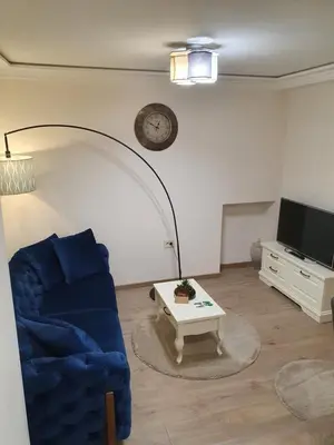 a living room with a blue couch and a coffee table at Apartment My Home in Belgrade