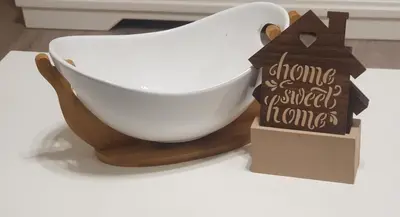 a white bowl on a wooden stand with a sign at Apartment My Home in Belgrade