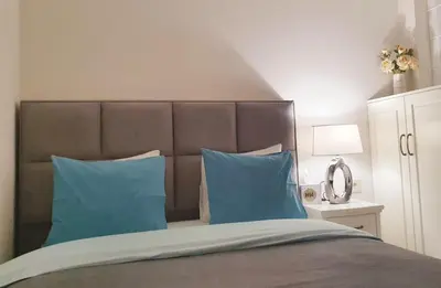 a bedroom with a large bed with blue pillows at Apartment My Home in Belgrade