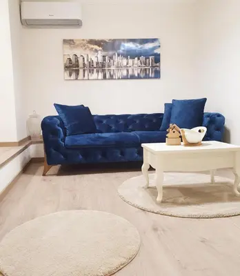 a living room with a blue couch and a coffee table at Apartment My Home in Belgrade